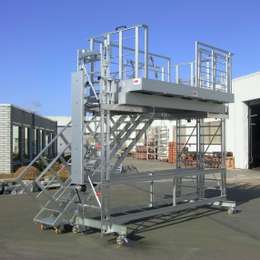 Mobiel, in hoogte verstelbaar aluminium industrieel werkplatform dat wordt gebruikt op een productielijn voor boot motoren.
