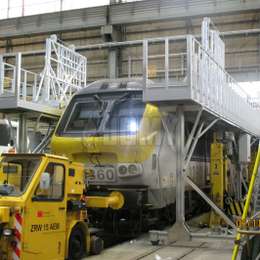 Plataformas de trabajo móviles con escaleras de acceso para mantenimiento de trenes en altura.