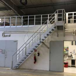 Zugangstreppe für ein industrielles Zwischengeschoss mit zusätzlichen Geländer zur Absturzsicherung.